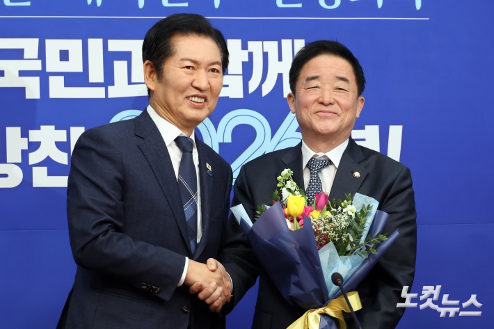 더불어민주당 정청래 대표(왼쪽)가 12일 서울 여의도 국회에서 열린 최고위원회의에서 강득구 신임 최고위원에게 꽃다발을 전달하고 있다.