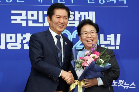 더불어민주당 정청래 대표(왼쪽)가 12일 서울 여의도 국회에서 열린 최고위원회의에서 문정복 신임 최고위원에게 꽃다발을 전달하고 있다.