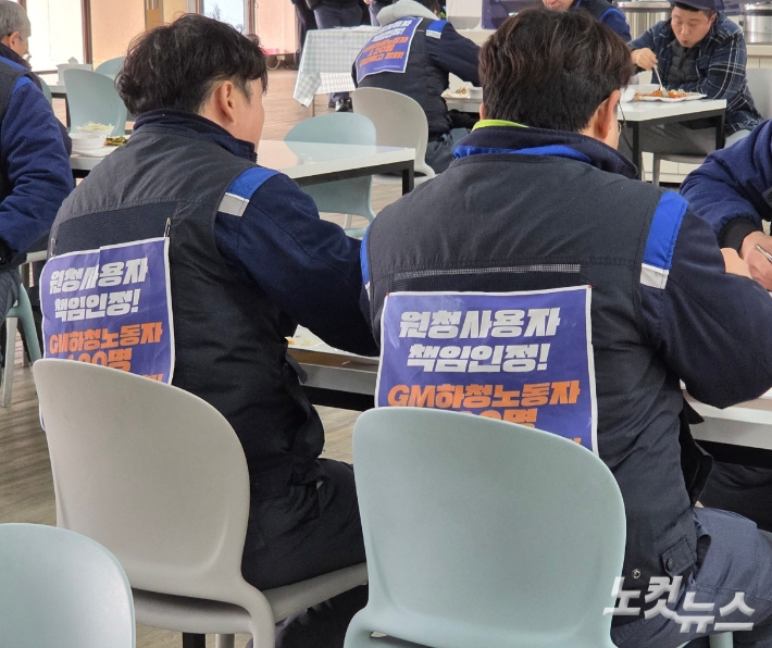 작업복 등판에 '원청 사용자 책임 인정' 글귀를 써붙인 하청노동자 100여 명이 물류센터 식당에서 노조비로 식사를 하고 있다. 박우경 기자