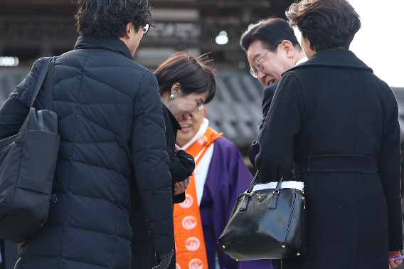 이재명 대통령과 다카이치 사나에 일본 총리가 14일 일본 나라현 대표 문화유적지인 호류지(법륭사)에서 기념촬영을 마친 뒤 이 대통령이 착용한 운동화에 대해 이야기를 하고 있다. 연합뉴스