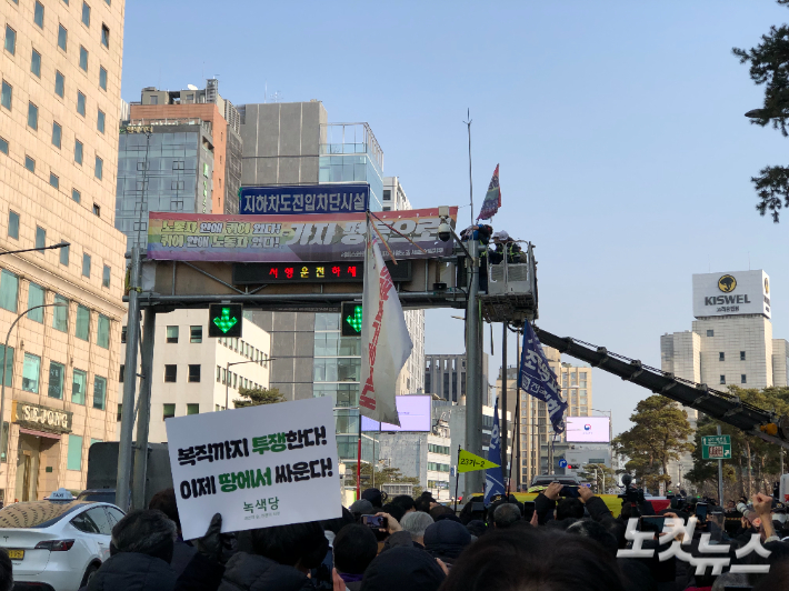 14일 서울 중구 세종호텔 앞에서 해고 철회를 요구하며 고공농성을 이어온 세종호텔 해고노동자 고진수 씨가 336일 만에 땅으로 내려오기 위해 크레인에 탑승하고 있다. 한국기독교교회협의회(NCCK) 총무 박승렬 목사, 세종호텔 이치호 조합원, 관광레저산업노조 최대근 위원장이 직접 크레인을 타고 올라가 고 씨와 포옹하고 있다. 장세인 기자