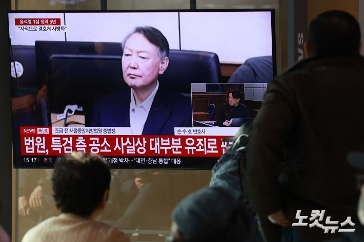 16일 오후 서울역 대합실에서 시민들이 고위공직자범죄수사처(공수처) 체포 방해 혐의 등으로 기소된 윤석열 전 대통령에 대한 1심 선고 공판 생중계를 지켜보고 있다.