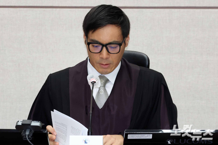 윤석열 전 대통령의 특수공무집행방해, 직권남용 권리행사방해 등 혐의 사건 첫 공판이 열린 26일 서울 서초구 서울중앙지법에서 백대현 부장판사가 자료를 살펴보고 있다. 사진공동취재단