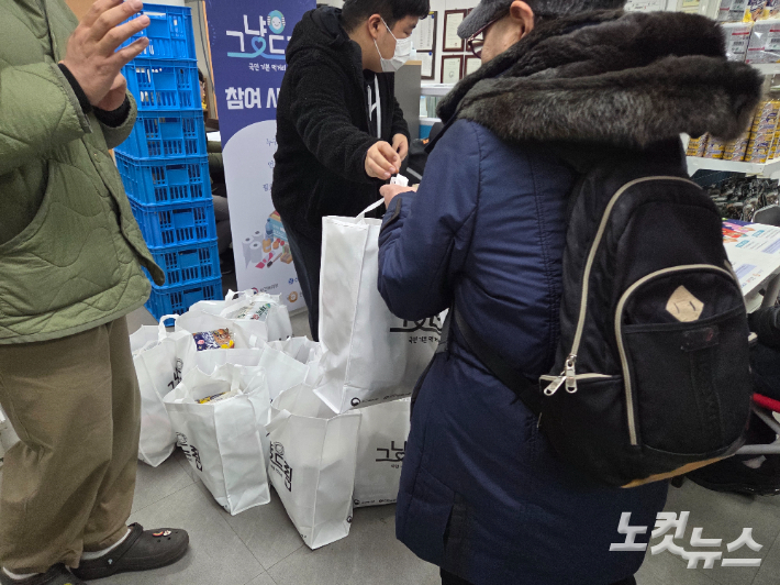 경기 평택시 '그냥드림' 매장을 찾은 한 시민이 식료품이 든 봉투를 받아가고 있다. 정성욱 기자