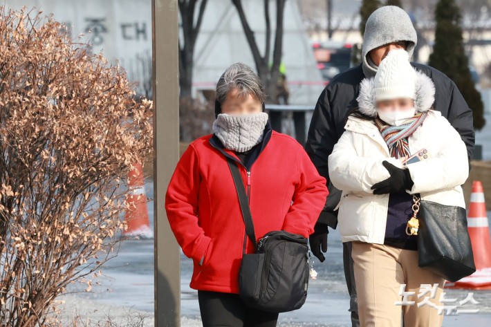 이번 주 내내 이번 겨울 들어 가장 강하고 긴 한파가 될 것으로 예상되는 가운데 19일 오전 서울 종로구 광화문광장에서 두꺼운 옷을 입은 관광객들이 발걸음을 재촉하고 있다.