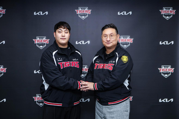 불펜 투수 조상우(왼쪽)가 21일 광주 기아챔피언스필드에서 원소속팀인 프로야구 KIA 타이거즈와 자유계약선수(FA) 계약을 맺은 뒤 심재학 KIA 단장과 악수하고 있다. KIA 타이거즈 