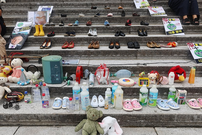 지난 8월 28일 서울 종로구 세종문화회관 계단에서 열린 가습기살균제 참사 14주년 기자회견에서 태아, 영유아, 어린이 피해 추모를 위한 유품들과 가습기 살균제 등이 전시돼 있다. 연합뉴스