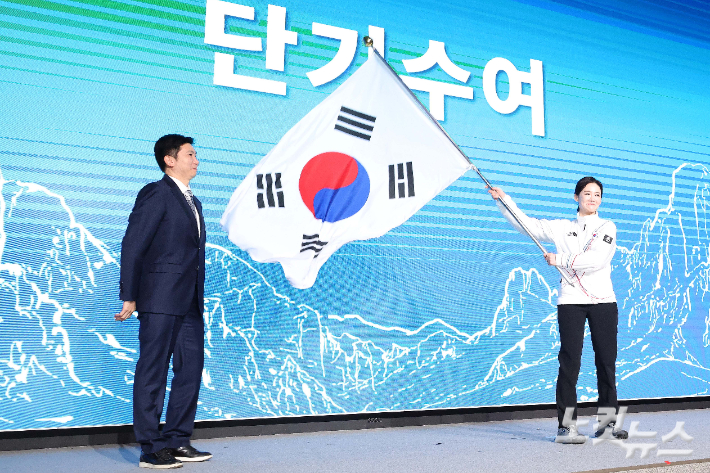 이수경 선수단장이 22일 서울 송파구 올림픽파크텔에서 열린 2026 밀라노코르티나 동계올림픽대회 결단식에서 단기를 흔들고 있다. 박종민 기자
