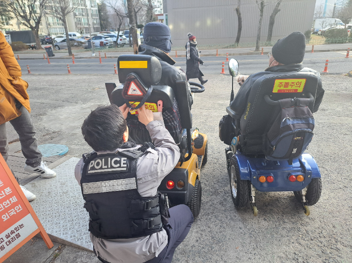광주 광산경찰서 우산지구대가 교통사고 위험에 노출된 교통약자 보호를 위해 전동휠체어 반사지 부착 활동을 진행하고 있다. 광주 광산경찰서 제공