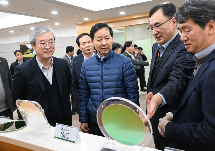 구윤철(가운데) 부총리 겸 재정경제부 장관이 23일 오후 충북 음성군에 있는 반도체 기업인 DB하이텍을 방문해 관계자로부터 DB 하이텍 웨이퍼 설명을 듣고 있다. 재정경제부 제공