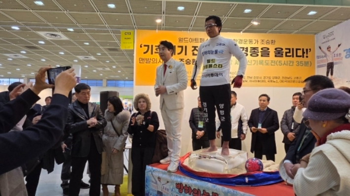 조승환 씨가 지난 24일 서울 코엑스에서 열린 '월드아트페스타' 개막식에서 '얼음 위에 맨발로 오래 서 있기' 퍼포먼스를 통해 기후위기의 심각성을 알리고 있다. 광양시 제공 