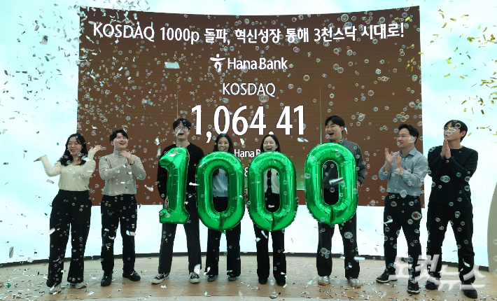 코스닥 지수가 7%가 넘는 급등세를 보이며 4년 만에 이른바 '천스닥'을 회복한 26일 서울 중구 하나은행 본점에서 직원들이 축하 세리머니를 하고 있다. 류영주 기자