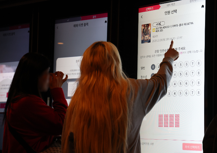 지난달 28일 서울 시내 한 영화관을 찾은 시민들이 영화 예매를 하고 있다. 연합뉴스
