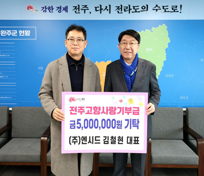 ㈜엔시드 김철현 대표(왼쪽)가 27일 우범기 전주시장에게 고향사랑기부금 500만원을 맡겼다. 전주시 제공