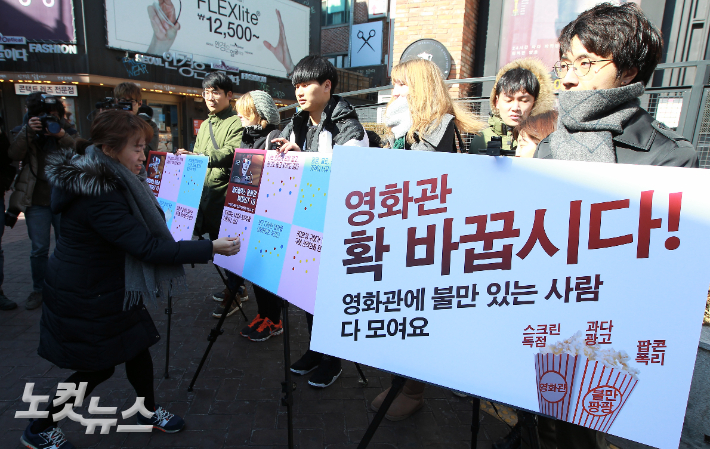 참여연대·민변민생경제위원회·청년유니온 주최로 지난 2015년 2월12일 서울 명륜동 CGV대학로 앞에서 진행된 'CGV·롯데시네마·메가박스 멀티플렉스 3사 관련 WORST 10' 발표 및 시민참여 캠페인에서 시민들이 설문내용에 스티커를 붙이고 있다. 황진환 기자