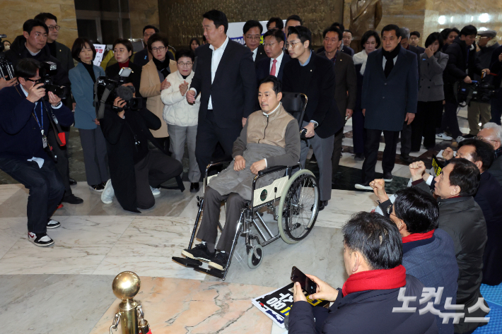 통일교·공천헌금 '쌍특검'을 요구하며 8일째 단식을 이어가던 장동혁 국민의힘 대표가 22일 서울 여의도 국회에서 단식을 중단하고 병원으로 향하며 지지자들의 응원을 받고 있다. 윤창원 기자