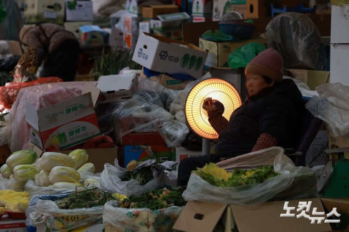 연일 한파가 이어지고 있는 가운데 29일 서울 서대문구 인왕시장에 상인들이 난로에 손을 녹이고 있다.