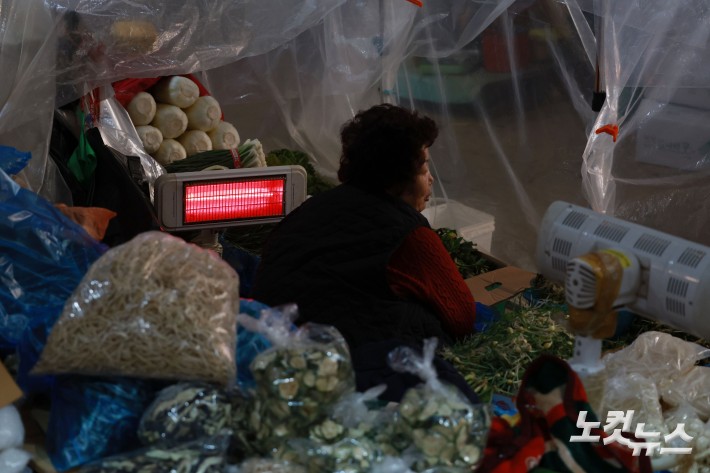 연일 한파가 이어지고 있는 가운데 29일 서울 서대문구 인왕시장에 상인들이 난로에 몸을 녹이고 있다.