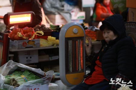 연일 한파가 이어지고 있는 가운데 29일 서울 서대문구 인왕시장에 상인들이 난로에 손을 녹이고 있다.