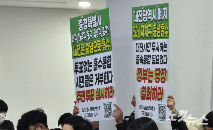 29일 열린 대전시의회·충남도의회 의장 공동 기자회견에서 시민들이 통합 반대와 주민투표를 주장하는 피켓(글판 시위)을 들고 있다. 고형석 기자