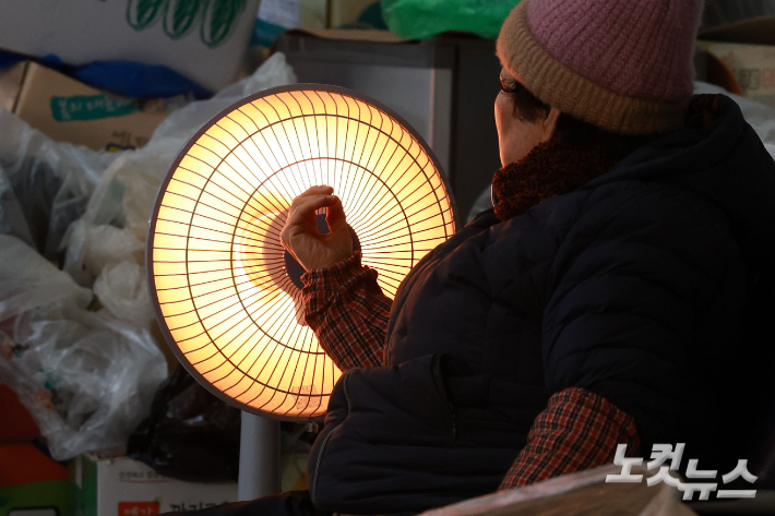 연일 한파가 이어지고 있는 가운데 29일 서울 서대문구 인왕시장에 상인들이 난로에 손을 녹이고 있다. 류영주 기자