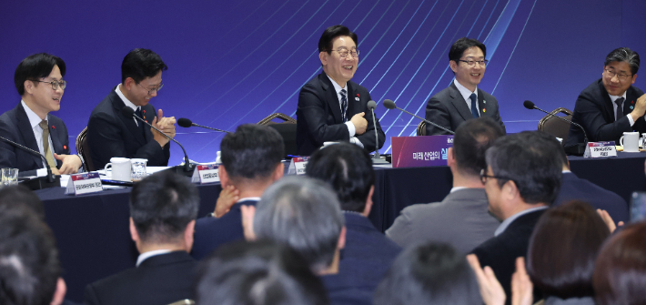 이재명 대통령이 지난 23일 울산전시컨벤션센터에서 열린 '울산의 마음을 듣다' 타운홀미팅 간담회에서 참석자 발언을 듣으며 웃고 있다. 연합뉴스