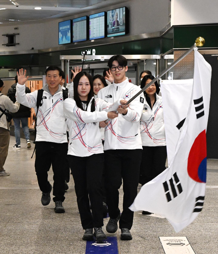 스피드스케이팅 박지우(사진 왼쪽)와 쇼트트랙 이준서가 31일(한국시간) 이탈리아 밀라노 말펜사 국제공항에서 태극기를 들고 2026 밀라노·코르티나담페초 동계 올림픽에 출전하는 한국 선수단을 이끌고 있다. 대한체육회 제공