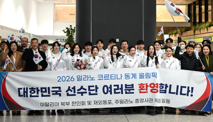 2026 밀라노·코르티나담페초 동계 올림픽에 출전하는 대한민국 선수단 본진이 31일(한국시간) 이탈리아 밀라노에 도착한 뒤 한인회 등이 준비한 현수막 뒤에서 파이팅을 외치고 있다. 대한체육회 제공