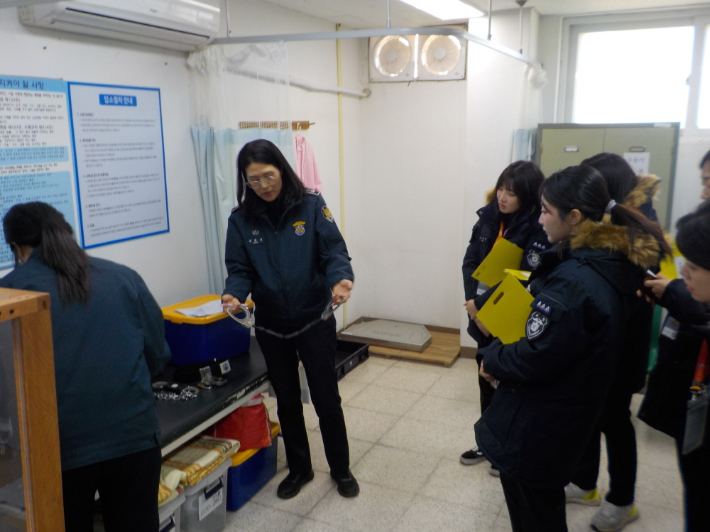 교도관이 수갑을 들어 보이며 사용 방법을 설명하고 있다. 화성직업훈련교도소 제공