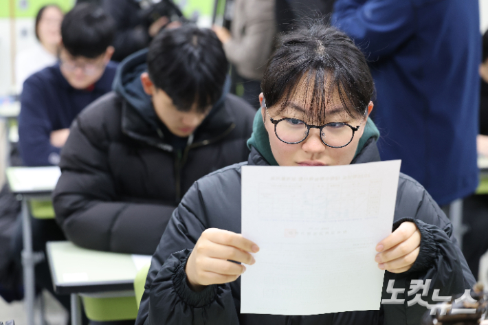 수험생들이 성적표를 확인하고 있다. 류영주 기자