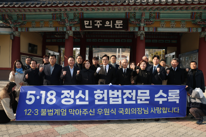 우원식 국회의장이 4일 국립 5·18 민주묘지를 분향한 후 민주의 문 앞에서 참석자들과 함께 5·18 정신의 헌법 전문 수록을 다짐하고 있다. 국회의장실 제공