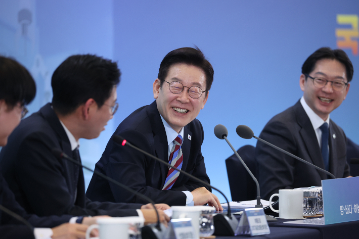 이재명 대통령이 6일 창원 성산구 창원컨벤션센터에서 '경남의 마음을 듣다' 타운홀미팅 간담회에서 배경훈 부총리 겸 과기부 장관의 발언에 웃고 있다. 연합뉴스