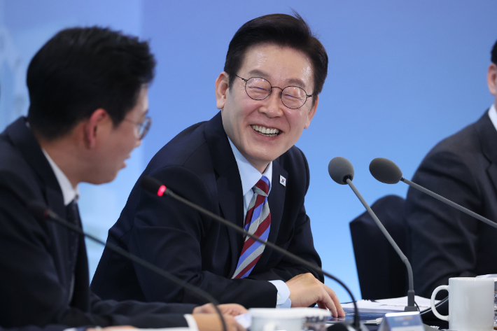 이재명 대통령이 6일 창원 성산구 창원컨벤션센터에서 '경남의 마음을 듣다' 타운홀미팅 간담회에서 배경훈 부총리 겸 과기부 장관의 발언에 웃고 있다. 연합뉴스