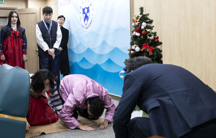 김욱(오른쪽 뒷모습) 배재대 총장이 10일 배재대 외국인 유학생들에게 세배받고 있다. 이날 유학생들의 세배는 한국 문화 체험의 하나로 진행됐다. 배재대 제공