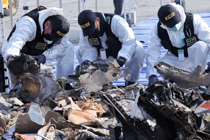 12일 무안국제공항에서 국립과학수사연구원 관계자들이 12·29 제주항공 여객기 참사 사고기 잔해를 조사하고 있다. 연합뉴스