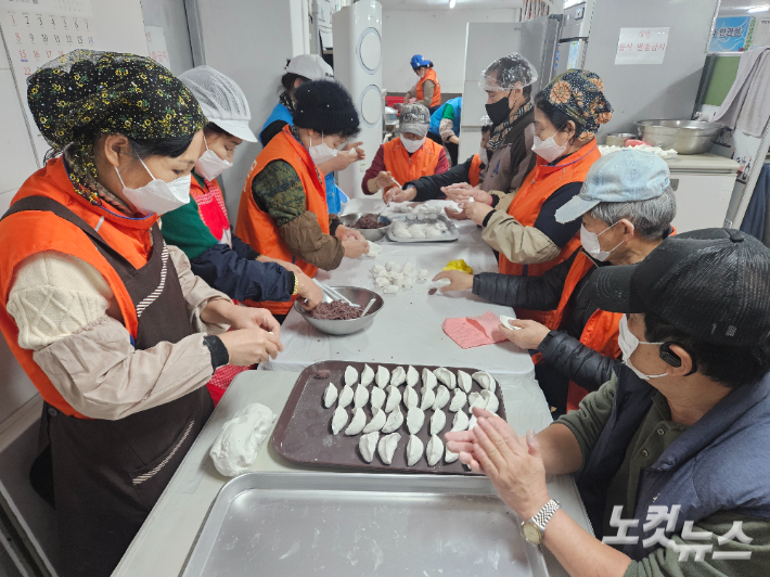 송편을 빚고 있는 자원봉사자들. 이원석 기자