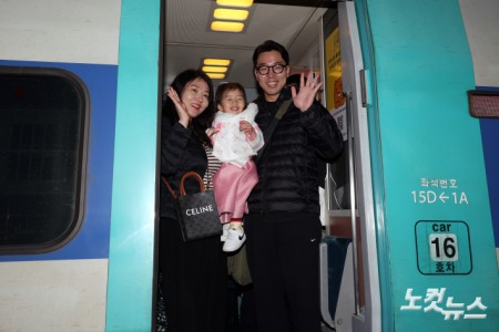 설 연휴를 하루 앞둔 13일 오전 서울 용산구 용산역에서 귀성길에 오르는 한 가족이 손을 흔들고 있다.