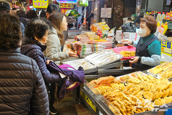 설 연휴를 하루 앞둔 13일 부산 부전시장에서 시민들이 각종 전을 구경하고 있다. 김혜민 기자 