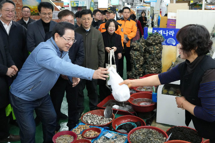 김영록 전라남도지사가 설 명절을 앞둔 13일 지역 전통시장인 광양 중마시장을 방문, 물품을 구매하며 상인들을 격려하고 있다. 전라남도 제공 
