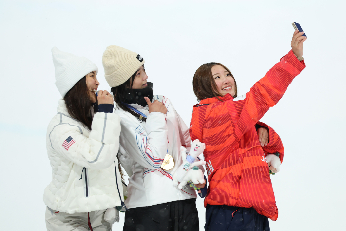 13일(한국 시각) 이탈리아 리비뇨 스노파크에서 열린 2026 밀라노·코르티나담페초동계올림픽 스키 스노보드 여자 하프파이프 시상식에서 금메달 최가온(가운데), 은메달 클로이 김(왼쪽), 동메달 요노 미츠키(일본) 선수가 갤럭시 Z 플립7 올림픽 에디션으로 빅토리 셀피를 찍고 있다. 삼성전자