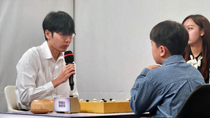 신진서 9단(사진 왼쪽)이 유하준 초단에게 대국 후 복기 과정에서 조언하고 있다. ㈜한국바둑방송 제공