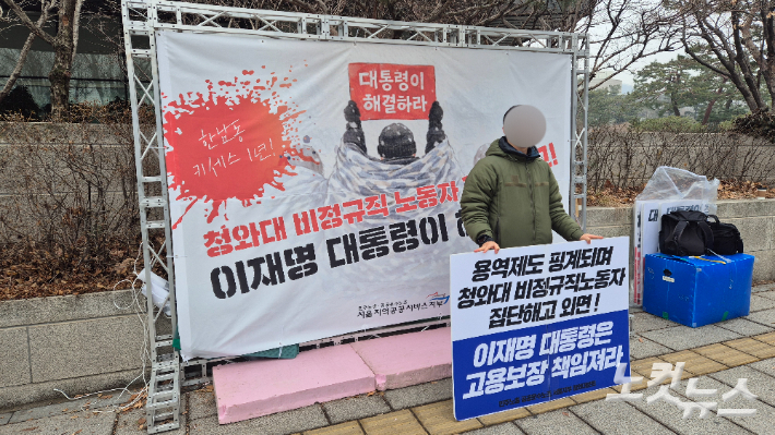 지난 13일 서울 종로구 청와대 인근에서 공공운수노동조합 서울지부 청와대분회장이 피켓을 들고 서 있다. 송선교 기자