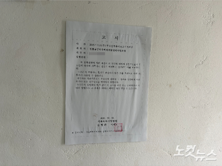 김우권씨 집에 붙은 북부지법 고시. 박인 기자 