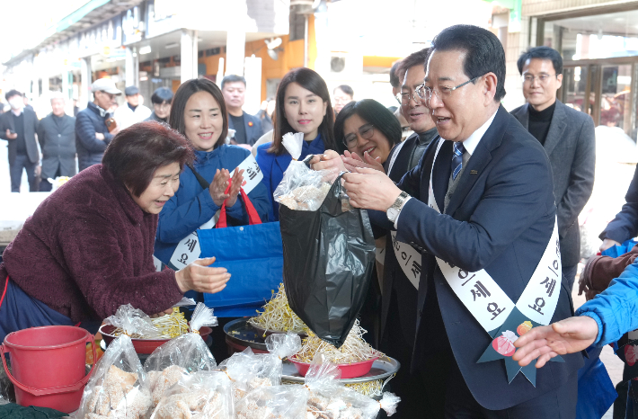 김영록 전라남도지사가 설 명절을 하루 앞둔 16일 오후 지역 전통시장인 순천 웃장을 방문, 물품을 구매하며 상인들을 격려하고 있다. 전라남도 제공