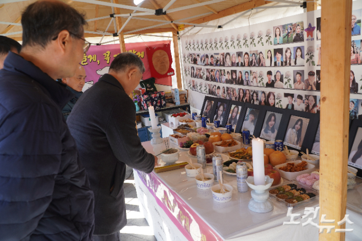 치킨, 맥주가 놓인 차례상에 분향하는 유족들. 심동훈 기자