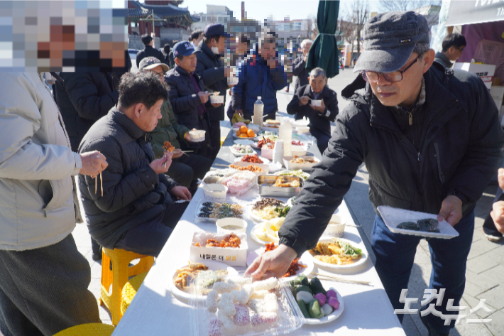 차례 이후 함께 음식을 나누는 유족과 시민들. 심동훈 기자
