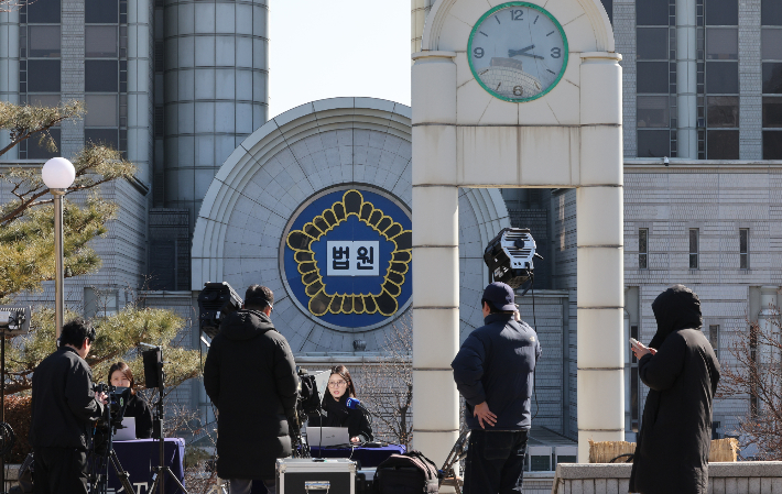 12·3 비상계엄과 관련한 윤석열 전 대통령의 내란 우두머리 혐의 사건 1심 선고를 앞둔 18일 서울 서초구 서울중앙지법에서 방송사 관계자들이 보도를 하고 있다. 연합뉴스