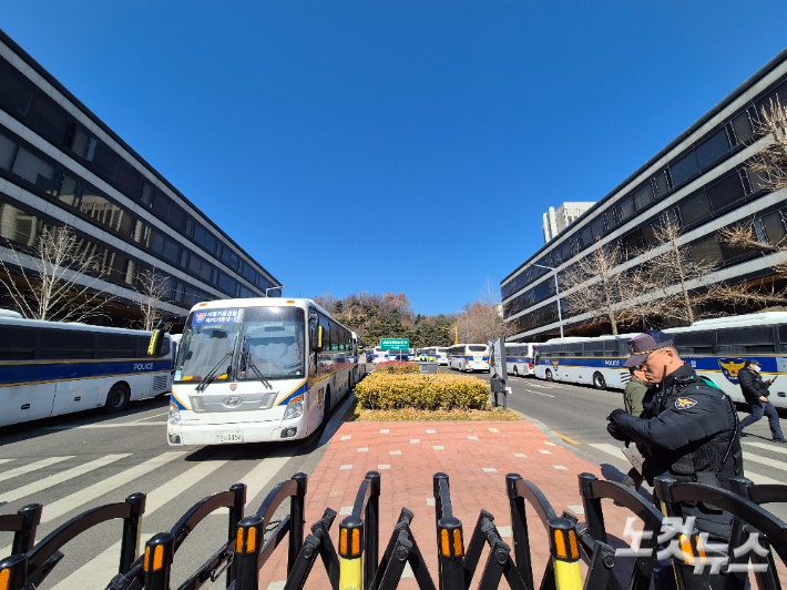 윤석열 전 대통령의 내란 우두머리 혐의에 대한 1심 선고가 이뤄지는 19일 오후, 서울 서초구 법원삼거리에서 서울중앙지법으로 향하는 6차선 도로에 경찰 차벽이 세워져 있다. 주보배 기자