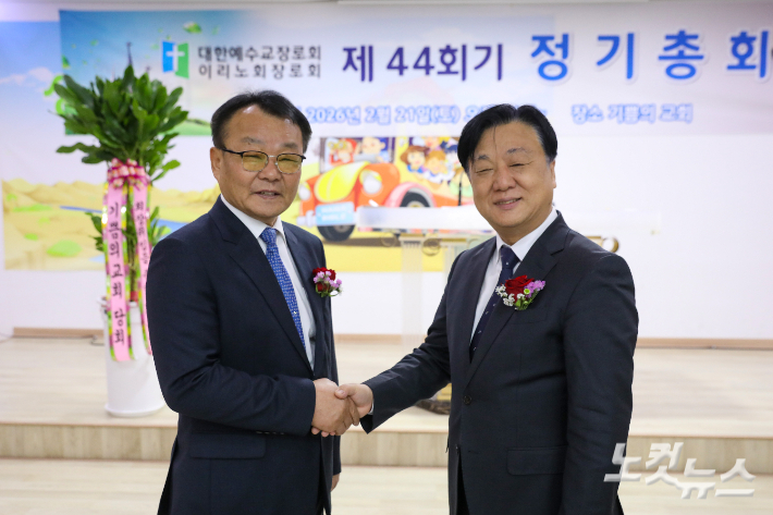 황도연 신임 회장(왼쪽)과 전상영 직전 회장이 정기총회에서 악수하며 인사를 나누고 있다. 최화랑 기자