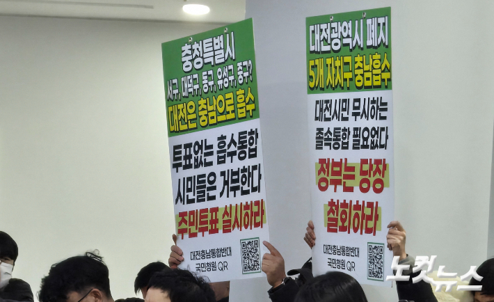 지난달 29일 열린 대전시의회·충남도의회 의장 공동 기자회견에서 자리에 시민들이 통합 반대와 주민투표를 주장하는 피켓(글판 시위)을 들고 있다. 고형석 기자